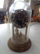 A brass anniversary clock under glass dome
