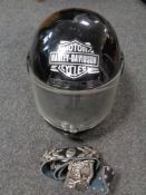 A Harley Davidson belt buckle with leather belt and a motorcycle helmet