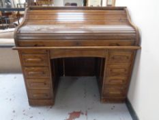 An Edwardian oak roll-topped double-pedestal desk.