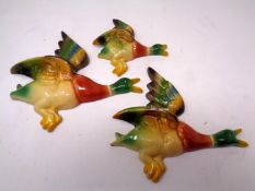 A set of three graduated cast metal flying duck ornaments.