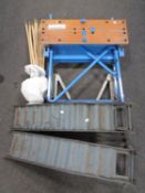 Two metal car ramps together with a set of drain rods and a folding workbench.
