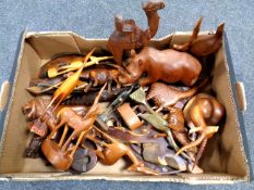 A box containing a quantity of tourist carvings including animal figures, a desk stand,