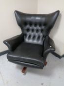 A 1960's vintage G-plan swivel armchair in black vinyl