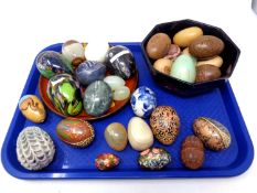 A tray containing a quantity of polished stone, treen and glass egg ornaments including Mdina glass.