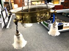 An antique brass pendant light fitting with three glass shades.
