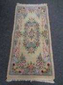 A Chinese embossed rug on cream ground.