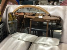 A 20th century frameless bevel edged mirror together with a further oval framed mirror.