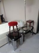 A nest of two contemporary black glass tables on metal legs together with a further oval coffee