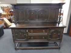 An Edwardian carved oak buffet back sideboard on barley twist legs.
