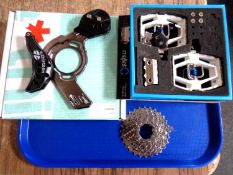 A Dura-ace bicycle seven-rig gear together with a pair of Mallet C bicycle cleats and a chain guard.