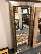 A contemporary mirror in a decorative frame, 58 x 140 cm.