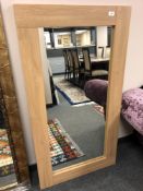 A contemporary light oak framed mirror, 71 x 130 cm.