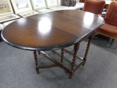 A barley twist gate leg table together with a set of six wheelback chairs