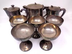 Three plated teapots together with five plated champagne glasses.