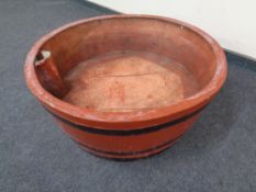 A large circular fibreglass planter in the form of a barrel.