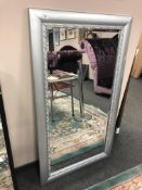A contemporary mirror in a silvered frame, 79cm x 139cm.