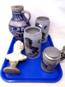 A tray containing a bust of Mozart on a marble base together with three salt glazed beer steins and