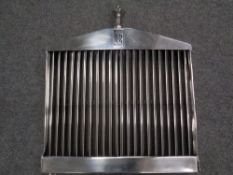 A Rolls-Royce chrome grill with silvered Spirit of Ecstasy mascot.