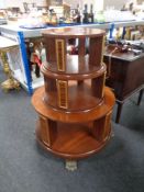 A circular revolving three tier bookcase on lion's paw feet.
