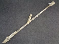 A carved bone blowdart pipe with darts in the form of a dragon.