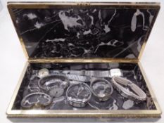 A brass and black marble table cigarette box containing seven assorted lady's and gent's