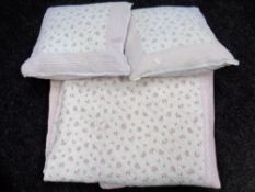 A hand-stitched floral quilt together with two cushions.