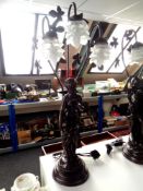 A contemporary three way figural resin table lamp, female figure with fruit basket.