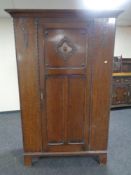 An Edwardian oak single door wardrobe.