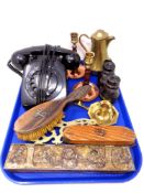 A tray containing assorted brass ware, antique field glasses, Bakelite telephone, brushes etc.
