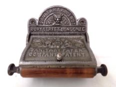 A reproduction cast iron Sanitary Paper Company toilet roll holder.