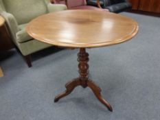 A circular mahogany tripod wine table