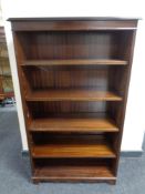 A set of open bookshelves in a mahogany finish.