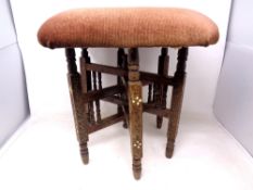 A footstool on an Indian six legged base.