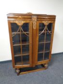 A carved oak double door display cabinet.