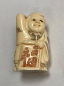 A carved bone Chinese netsuke - Gentleman carrying a scroll