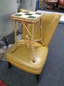 A mid-20th century bedroom chair upholstered in vinyl together with a wicker tile top plant table.