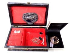 A lacquered jewellery box containing a small quantity of jewellery including enamelled earrings