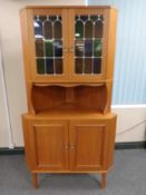 A continental teak and leaded glass corner cabinet