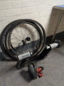 An Elite Novo Smart bike trainer together with two bike wheels and two tires.