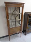 A late 19th century inlaid mahogany display cabinet on raised legs.