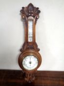 A carved oak barometer. (AF) CONDITION REPORT: Crack to glass.