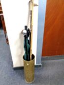 A brass embossed stick pot containing a quantity of walking sticks,