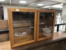 A mid-20th century teak double door glazed wall cabinet.