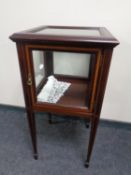 A Victorian style inlaid mahogany glazed curio cabinet on raised legs.