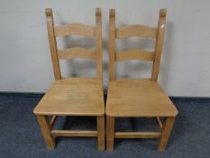A pair of pine ladder back chairs.