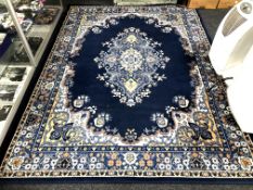 Two woolen rugs with central medallions on blue and red ground.