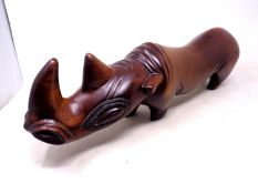 A carved hardwood figure of a rhinoceros (length 50cm).