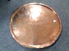A 19th century hammered copper charger (width 97cm).