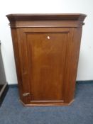 A 19th century pine single door hanging corner cabinet.