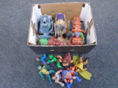 A box containing vintage He-Man figures.